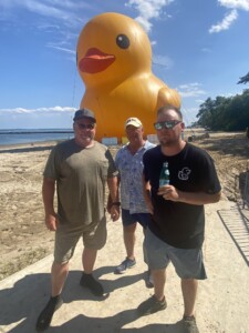 (PHOTO: Duck wranglers Craig Samborski, Marc Burr and Jase Wiardasince on Friday at Playland Beach in front of their charge, the world's largest rubber duck, 61' tall Mama Duck.)