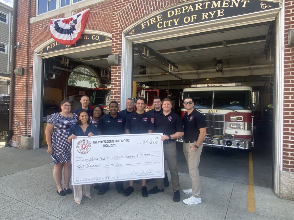 (PHOTO: On Tuesday afternoon August 1, 2023, Rye Professional Firefighters Local 2029 presented a $10,000 check to Maria Fareri Children’s Hospital. The donation is part of $26,000 the union has raised since last December benefiting five non-profits. The check presentation was made at the Rye FD Locust Avenue headquarters. Front row (left to right): Tina Cocuzza, MD, medical director EMS, Maria Fareri Children’s Hospital; Firefighter Andre Wolfe, Firefighter Joe Tolve; Firefighter Andrew Wood; Firefighter and Rye Professional Firefighters Local 2029 President Ricky Colasacco. Back row (left to right): Hilary Sparling, manager of central development initiatives, Maria Fareri Children’s Hospital; Firefighter Sal Inguanti; Natalie Surin, manager of central development initiatives, Maria Fareri Children’s Hospital; Lieutenant Clyde Pitts 3rd; Firefighter Will Junior.)