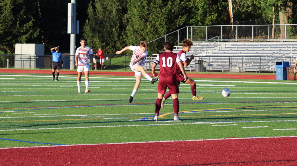 (PHOTO: Rye Boys Varsity Soccer's Kieran Traynor strikes the ball from 23 yards out for Rye's second goal. Credit: Alvar Lee.)