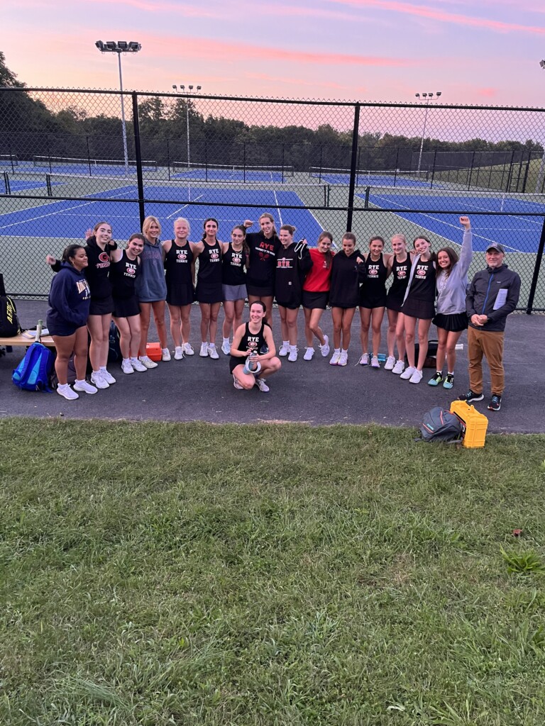 (PHOTO: After the thrilling win versus Harrison on Thursday, the Rye Girls Varsity Tennis team surrounds their ace Sasha Sherman, the Shermanator!)