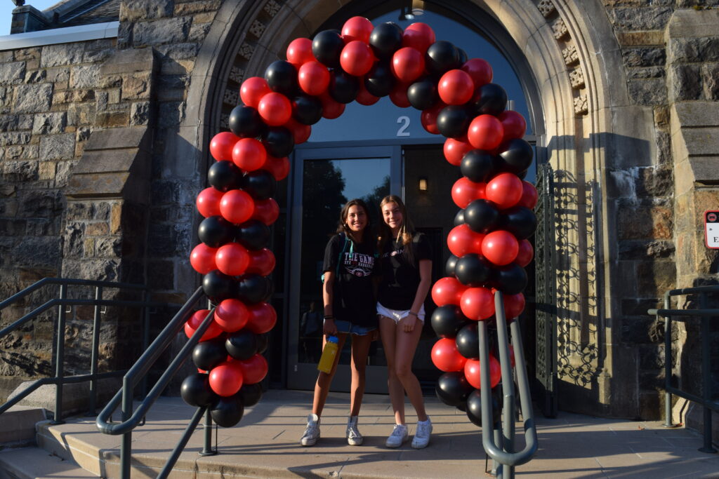 (PHOTO: Under the Garnet arch on Wednesday: (student of left is unidentified, 11th grader Ella Erickson on right.)