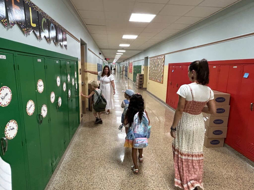 (PHOTO: At the first day of school 2023 at Midland Elementary. Mrs. Bellofatto takes students to their 1st grade classroom.)