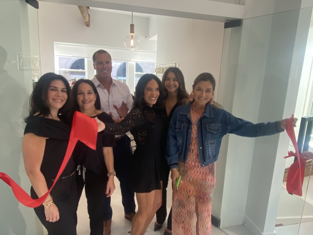 (PHOTO: City of Rye Deputy Mayor Carolina Johnson (far right) with Nicole Frontera (third from right), cutting the ribbon with the staff at the grand opening of the new medical spa at 77 Purchase Street, on Thursday, September 21, 2023.)