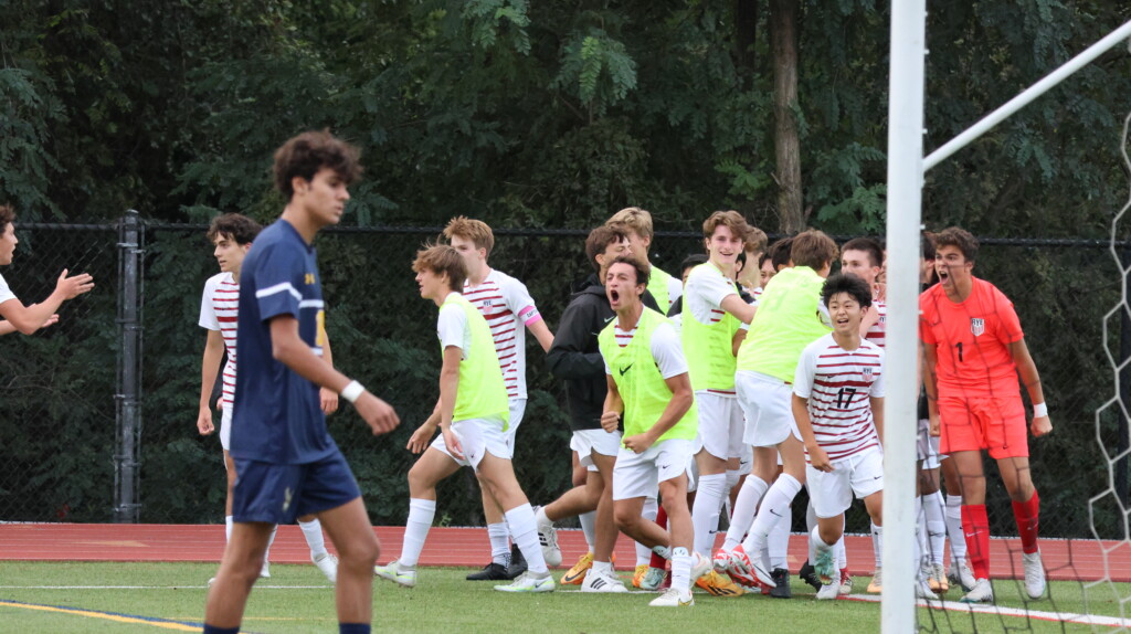 (PHOTO: Rye Boys Varsity Soccer celebrating the goal in the corner on Wednesday at Pelham. Credit: Alvar Lee.)