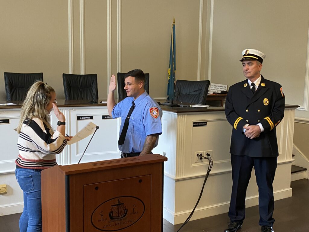 (PHOTO: New Rye Fire Fighter Brandon Antolino was sworn in by Deputy City Clerk Kayla Garritano on Tuesday, September 26, 2023. Captain John McDwyer is on the right.)