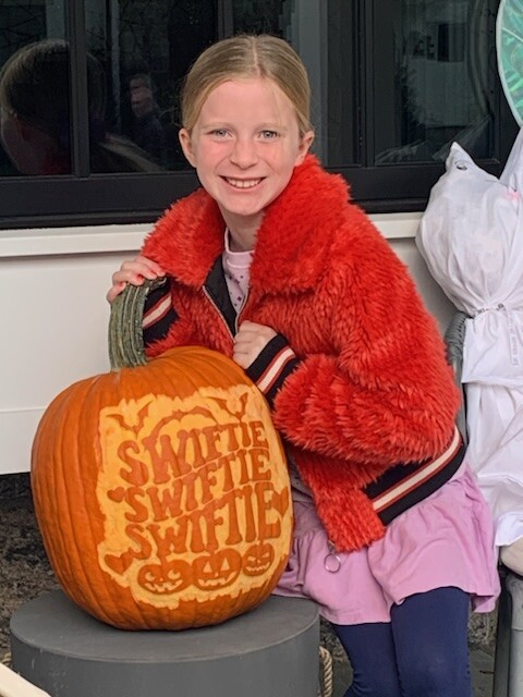 (PHOTO: Nina Orr was the lucky raffle winner of the coveted “Swiftie” pumpkin at the annual Halloween window paints event on October 22, 2023.)