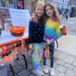 (PHOTO: Bake sale volunteers, shoppers or both? Charlotte Pellarin and Maggie Finnegan support the annual bake sale at the annual Halloween window paints event on October 22, 2023.)