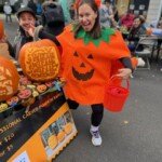 (PHOTO: Children’s Philanthropy of Rye volunteer Katie Finnegan dressed for the occasion and facilitated the specialty carved pumpkin raffle. Shown here at the annual Halloween window paints event on October 22, 2023.)