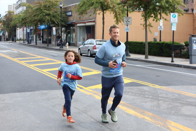 (PHOTO: At the 2023 annual Miles for MOMS (Meals of Main Street) race: Rye dad Zach Gibbs and his son Hoster make their way down Main Street in Port Chester.)