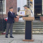 (PHOTO: Rye Boy Scout Troop 2 Scoutmaster Jon Ball recognized Fred deBarros and American Legion Post 128 for their service at the Veterans Day ceremony on the Rye Village Green November 11, 2023.)