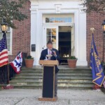 (PHOTO: Legionnaire Terry McCartney recounted the story of two Rye World War II veterans during the Veterans Day ceremony on the Rye Village Green November 11, 2023.)