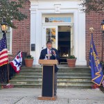 (PHOTO: Legionnaire Terry McCartney recounted the story of two Rye World War II veterans during the Veterans Day ceremony on the Rye Village Green November 11, 2023.)