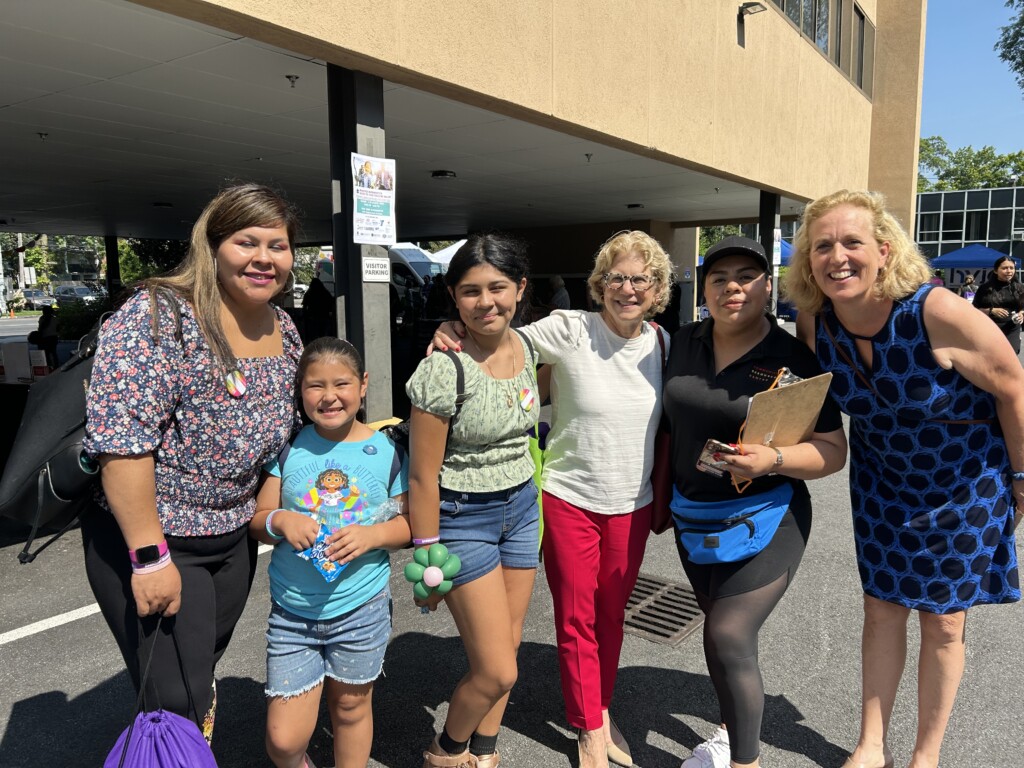 (PHOTO: Open Door health fair with NYS Senator Shelley Mayer (white shirt), Open Door Foundation Board Chair Jamie Jensen (far right), and community participants.)