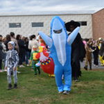 (PHOTO: Osborn Elementary School students assembling for their parade onto The Osborn retirement community campus on October 31, 2023 to celebrate Halloween.)