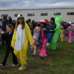 (PHOTO: Osborn Elementary School students assembling for their parade onto The Osborn retirement community campus on October 31, 2023 to celebrate Halloween.)