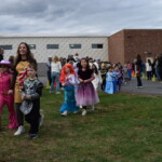 (PHOTO: Osborn Elementary School students assembling for their parade onto The Osborn retirement community campus on October 31, 2023 to celebrate Halloween.)