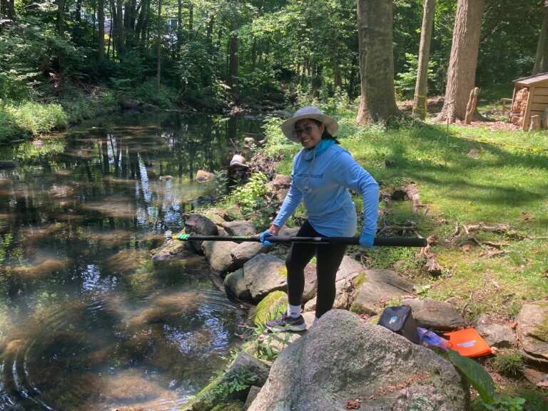 (PHOTO: Save the Sound's Environmental Analyst Ameera Khan sampling water in July 2023.)