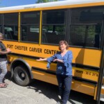 (PHOTO: Michael Williams, Carver Center logistics coordinator, with CEO Anne Bradner with the group's school bus.)