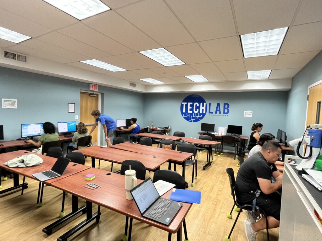 (PHOTO: The Carver Center tech lab. Standing in the blue shirt is student Francisco Luz, part of the Rye Country Day School Community Engagement Fellowship Program's adult literacy class in summer 2023.)