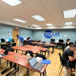 (PHOTO: The Carver Center tech lab. Standing in the blue shirt is student Francisco Luz, part of the Rye Country Day School Community Engagement Fellowship Program's adult literacy class in summer 2023.)