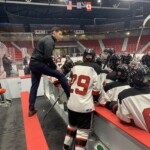 (PHOTO: Rye Lifer and Rye Boys Varsity Hockey Coach Peter Thomas giving pregame coaching instructions to Rye Varsity at Lake Placid, February 2022.)