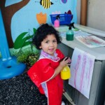 (PHOTO: Jasllyn having fun with water and paint on the playground of All Souls Community Center in Port Chester in the spring of 2023.)