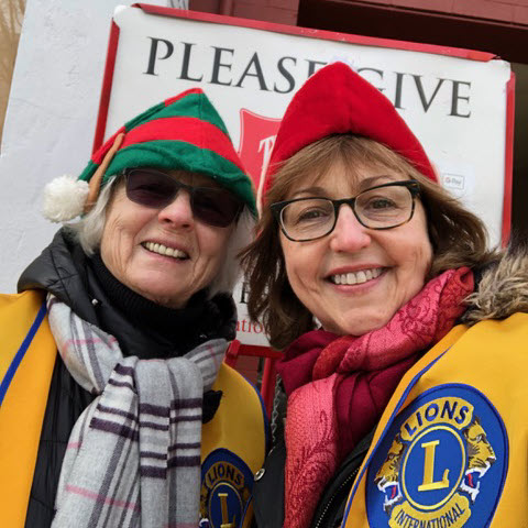 (PHOTO: Lions Barbara Brunner and Co-President Ann Higgins ringing the bell in downtown Rye for the Salvation Army.)