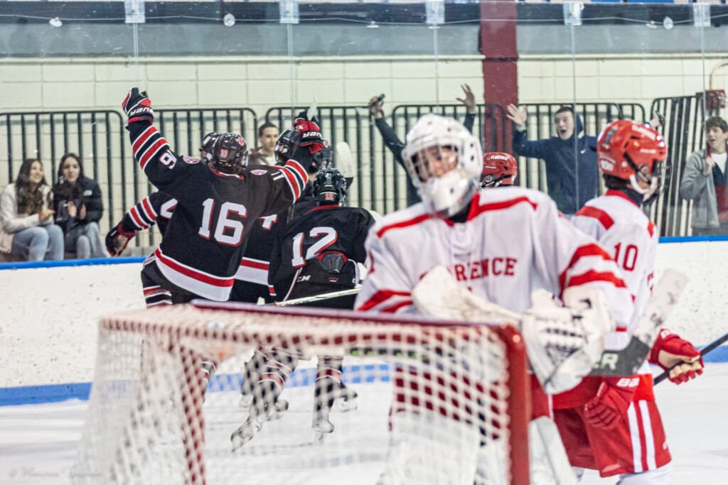 (PHOTO: Rye Boys Varsity Hockey celebrates a second period goal at their season opener on Saturday.)