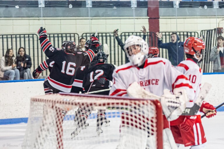 (PHOTO: Rye Boys Varsity Hockey celebrates a second period goal at their season opener on Saturday.)