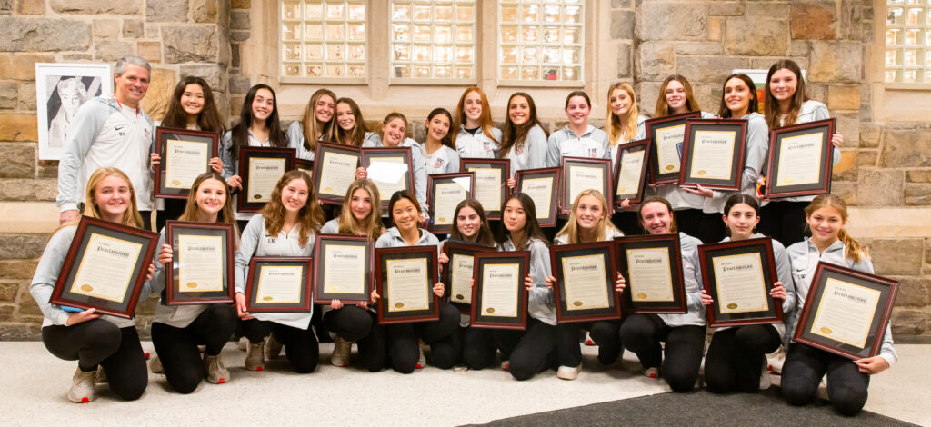 (PHOTO: Coach Rich Savage and the champion Rye High School Girls Varsity Soccer team with their City of Rye proclamations. Credit: Aileen Brown.)