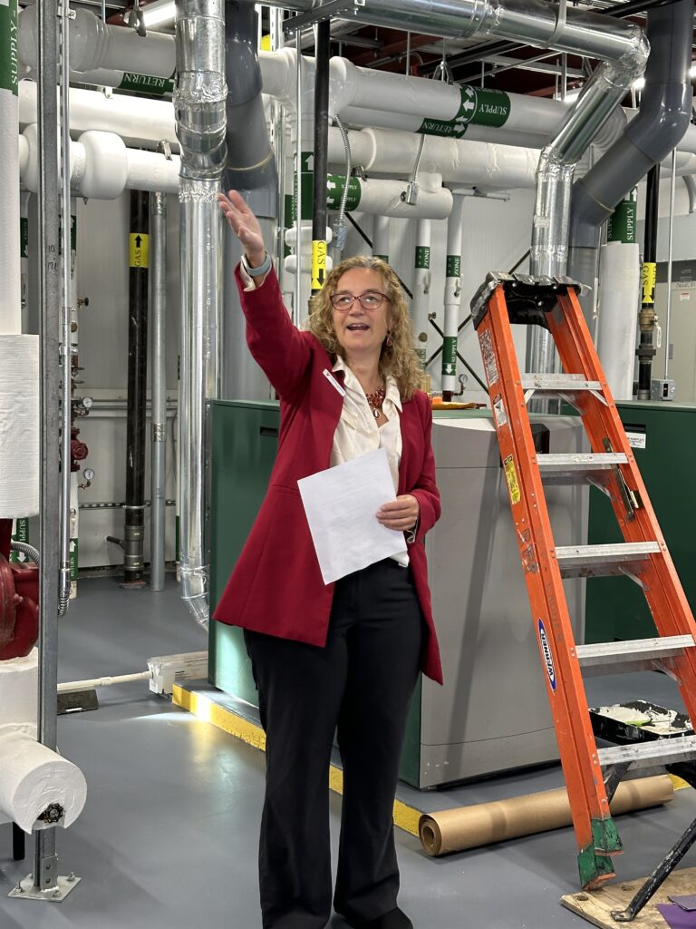 (PHOTO: Rye Y CEO Sabrina Murphy unveils the 900-square-foot rooftop “boiler house” that will shelter the Y’s two boilers and most of the organization’s mechanical and electrical panels from future flooding.)