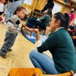 (PHOTO: Teacher Carolina Ramon-Caro with Odin (child). Playing in Port Chester at All Souls Community Center, part of 5 Steps to Five programming.)