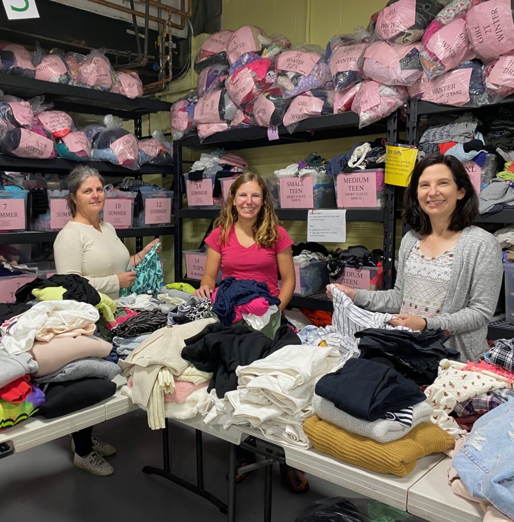(PHOTO: The Sharing Shelf's Kathy Ellis, Kathryn Ahitow and Kate Graham sorting clothing in the clothing bank in 2021.)