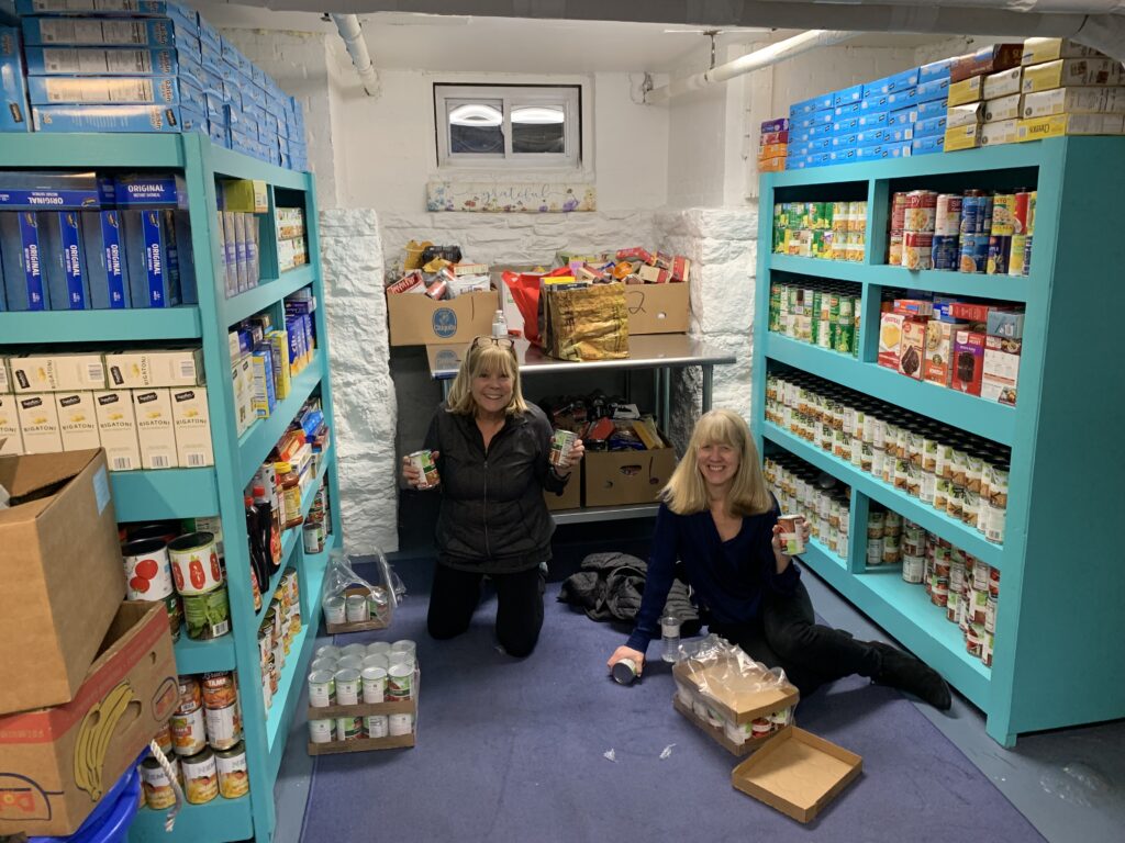 (PHOTO: Sue Wexler, director of community outreach for Bread of Life [aka Giving Tree Global] and winner of the 2023 Rye Human Rights Award winner stocking shelves with Loretta Calandruccio at the group's food pantry in Rye.)