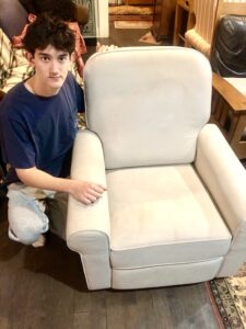 (PHOTO: PHOTO Furniture restorer and Rye High School junior Luke Latkany with a restored glider chair.)