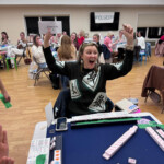 (PHOTO: At The Children's Philanthropy of Rye's Mahjong for a Cause! fundraiser, Abbie Durkin wins a raffle prize from sponsor The Granola Bar. Several local businesses supported the event, including longtime supporter Rye Country Store.)