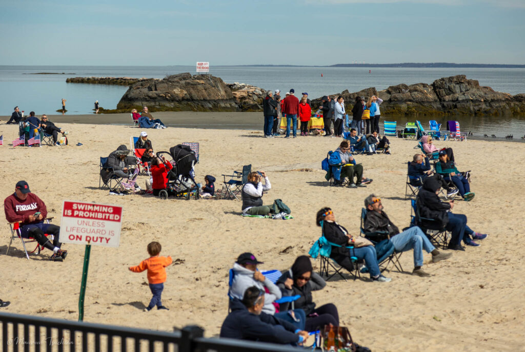 (PHOTO: The solar eclipse on April 8, 2024 brought out residents to Oakland Beach in Rye Town Park. There were no lifeguards or science teachers on duty. Credit: Maureen Tsuchida.)