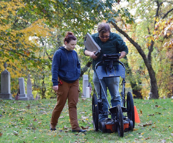 (PHOTO: Cole Peterson and Fiona Jones of Heritage Consultants conducting the ground penetrating radar survey within the African American Cemetery in Rye.)