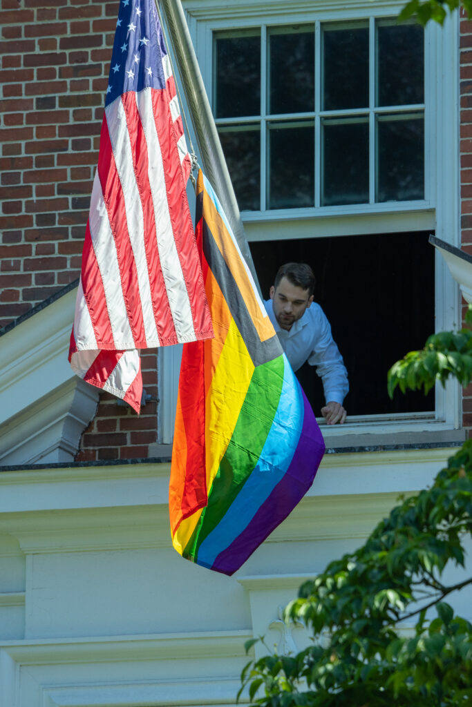 (PHOTO: John Sullivan, the new assistant to the City Manager, puts out the Pride flag at City Hall on Friday afternoon, May 31, 2024. Credit: Alex Lee.)