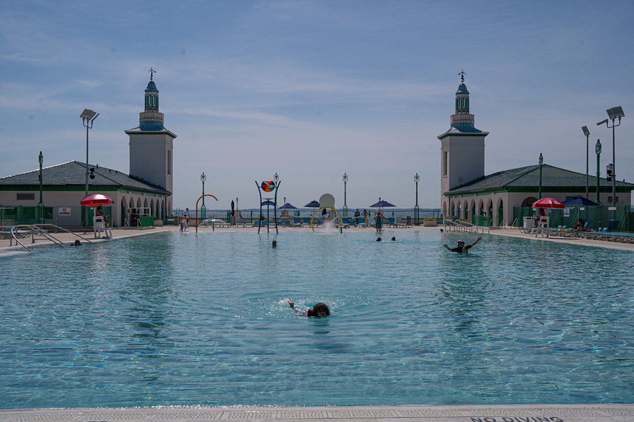 (PHOTO: Playland Pool Saturday morning, May 25, 2024. The pool has an extensive shallow area with water features perfect for younger children. Credit: Justin Gray.)