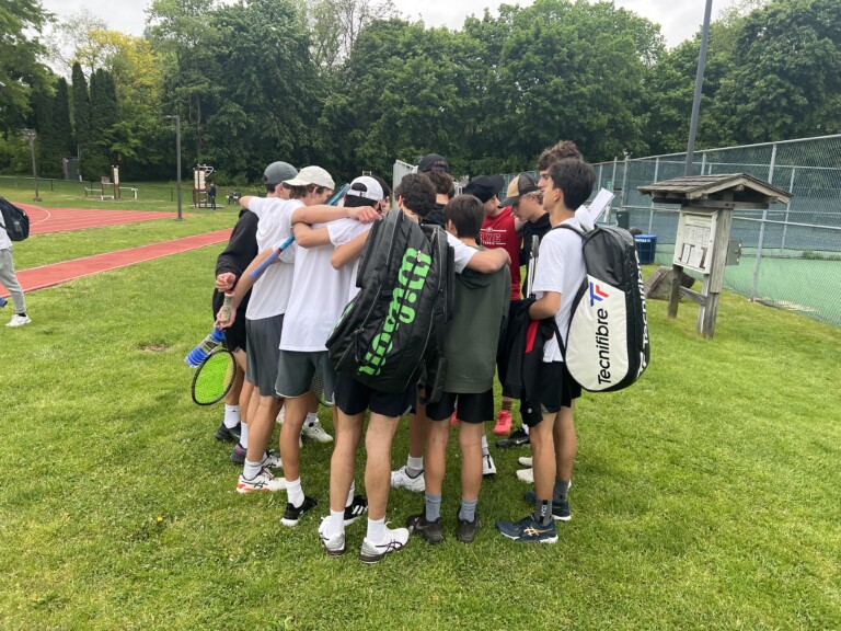 (PHOTO: The Boys Varsity Tennis team huddles before its semi-final matchup against Scarsdale)