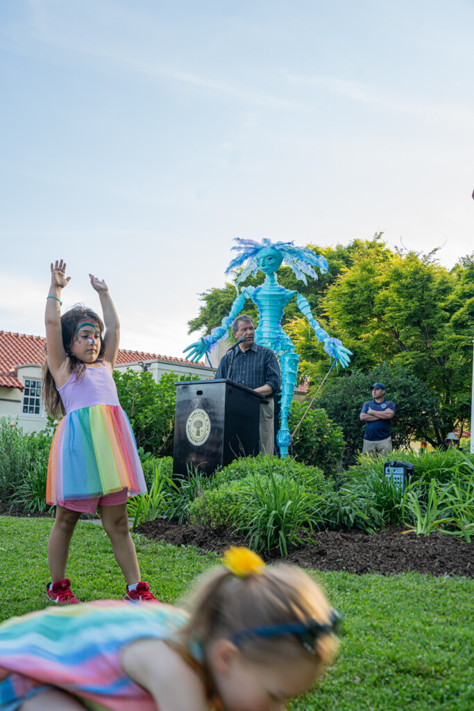 (PHOTO: Westchester County Executive George Latimer addresses the Pride crowd while others practice cartwheels.)