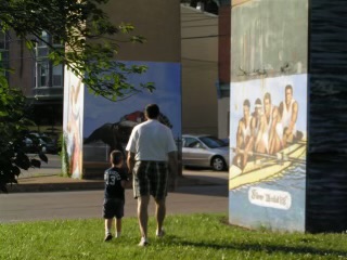 (PHOTO: Gus Rodriguez at age four with his father Raoul looking at a mural of Raoul's Olympic 4 achievement.)