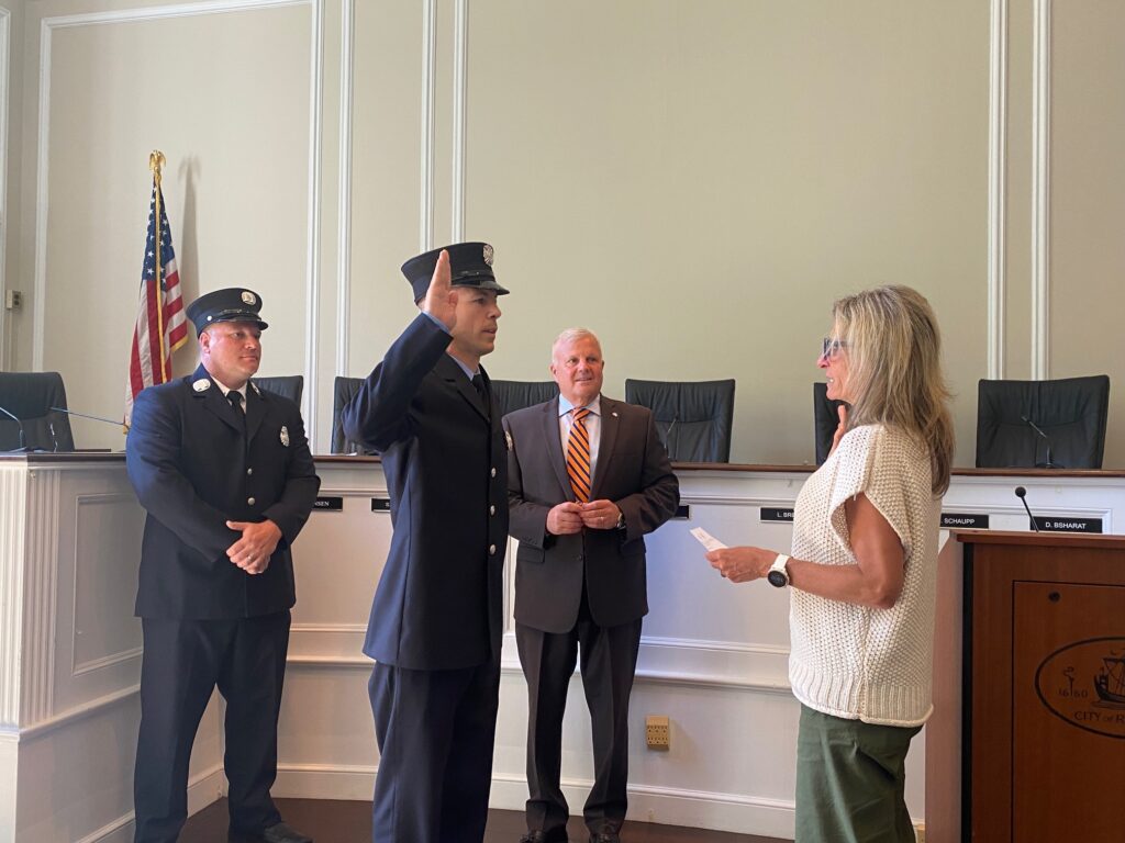 (PHOTO: New Rye FD Lieutenant Joseph Ganci is sworn in by Rye City Clerk Noga Ruttenberg. Looking on: Rye FD Captain Clyde Pitts and Rye Public Safety Commissioner Mike Kopy.)