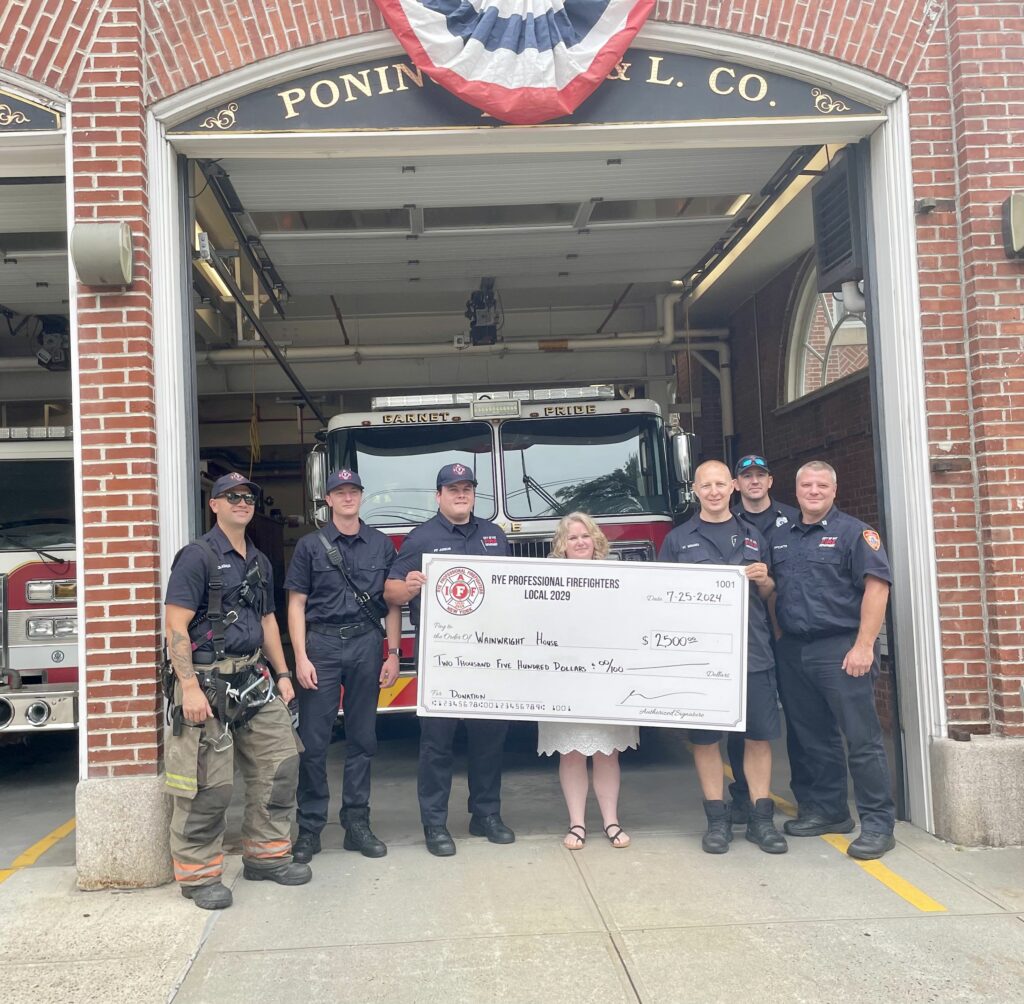 (PHOTO: Rye Professional Firefighters Local 2029 presented a $2,500 donation to Jessica Zamek of Wainwright House. Right to left: Firefighter Colasacco, Firefighter Ahearn, Firefighter  Junior, Jessica Zamek of Wainwright House, Firefighter Inguanti, Lieutenant Cotter, and Captain Pitts.)