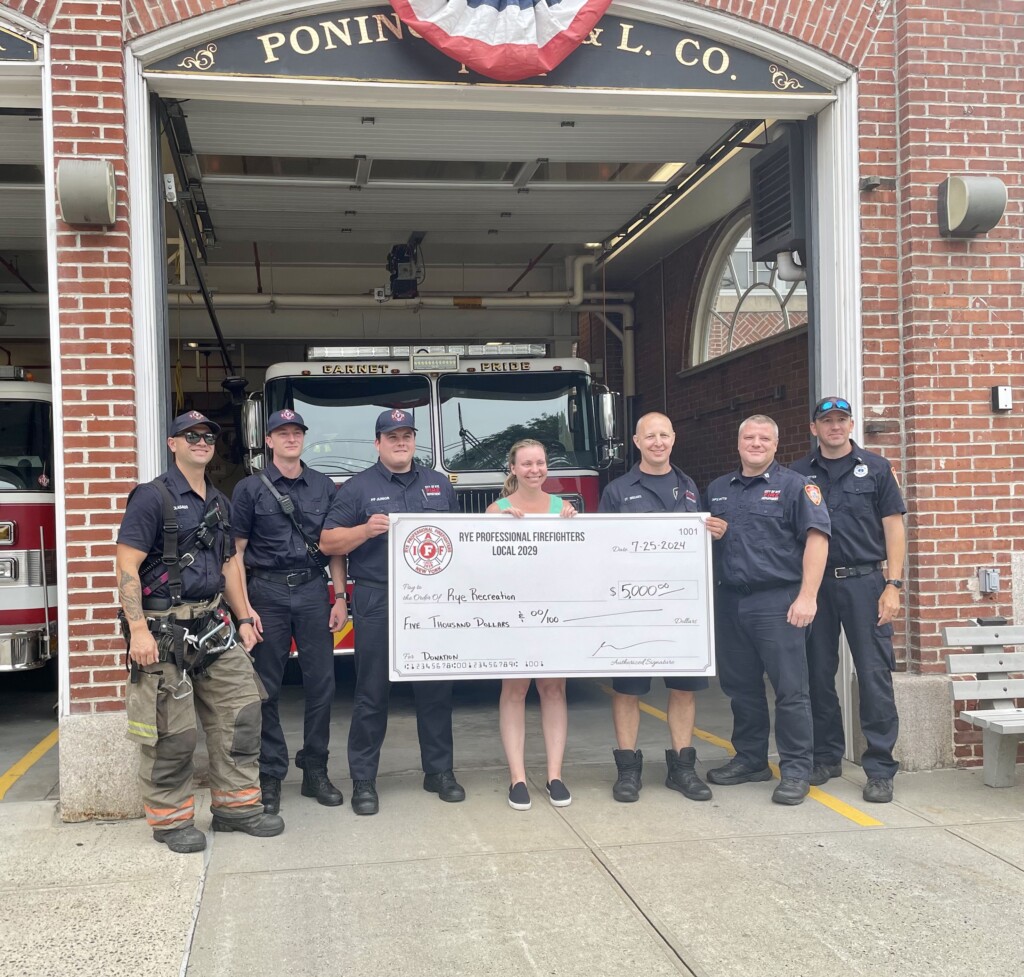 (PHOTO: Rye Professional Firefighters Local 2029 presented a $5,000 donation to Erin Mantz of Rye Recreation. Right to left: Firefighter Colasacco, Firefighter Ahearn, Firefighter Junior, Erin Mantz of Rye Recreation, Firefighter Inguanti, Lieutenant Cotter, and Captain Pitts.)