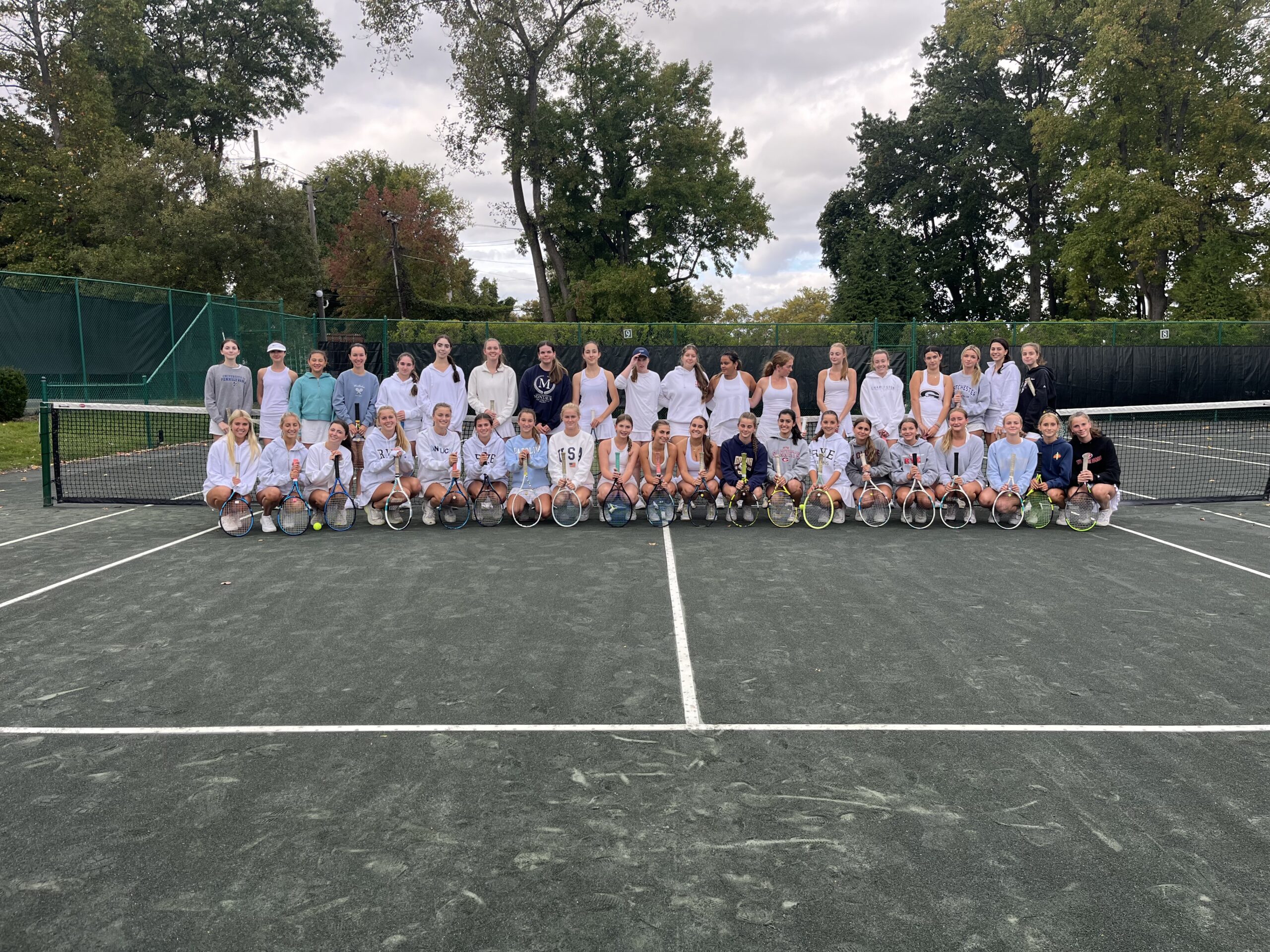 (PHOTO: The entire Rye Varsity Tennis program poses for a photo at a practice at Manursing Island Club.)