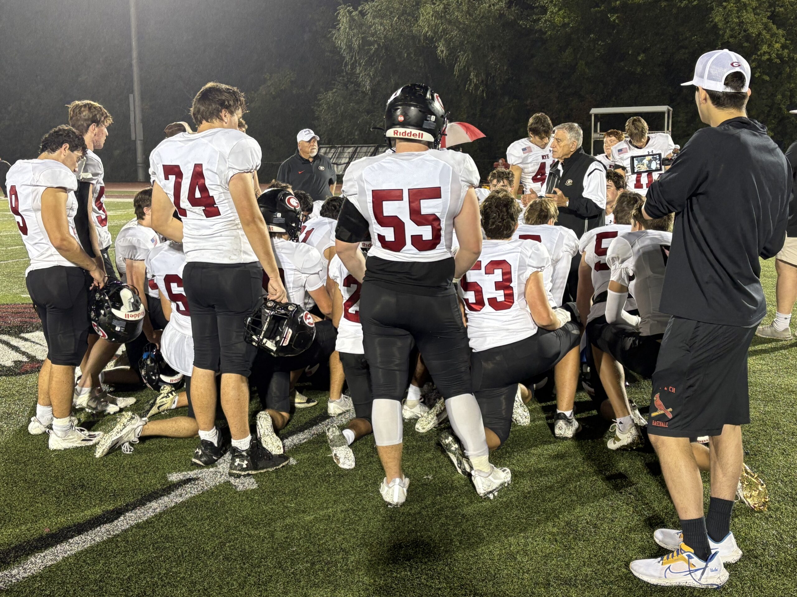 (PHOTO: The Rye Football Team huddles after defeating Nyack in Week 4.)