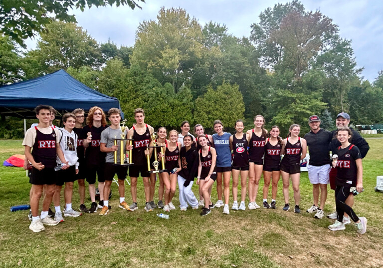 (PHOTO: The Rye Varsity Cross Country team poses with trophies after securing victory on both the boys and girls sides on Wednesday.)