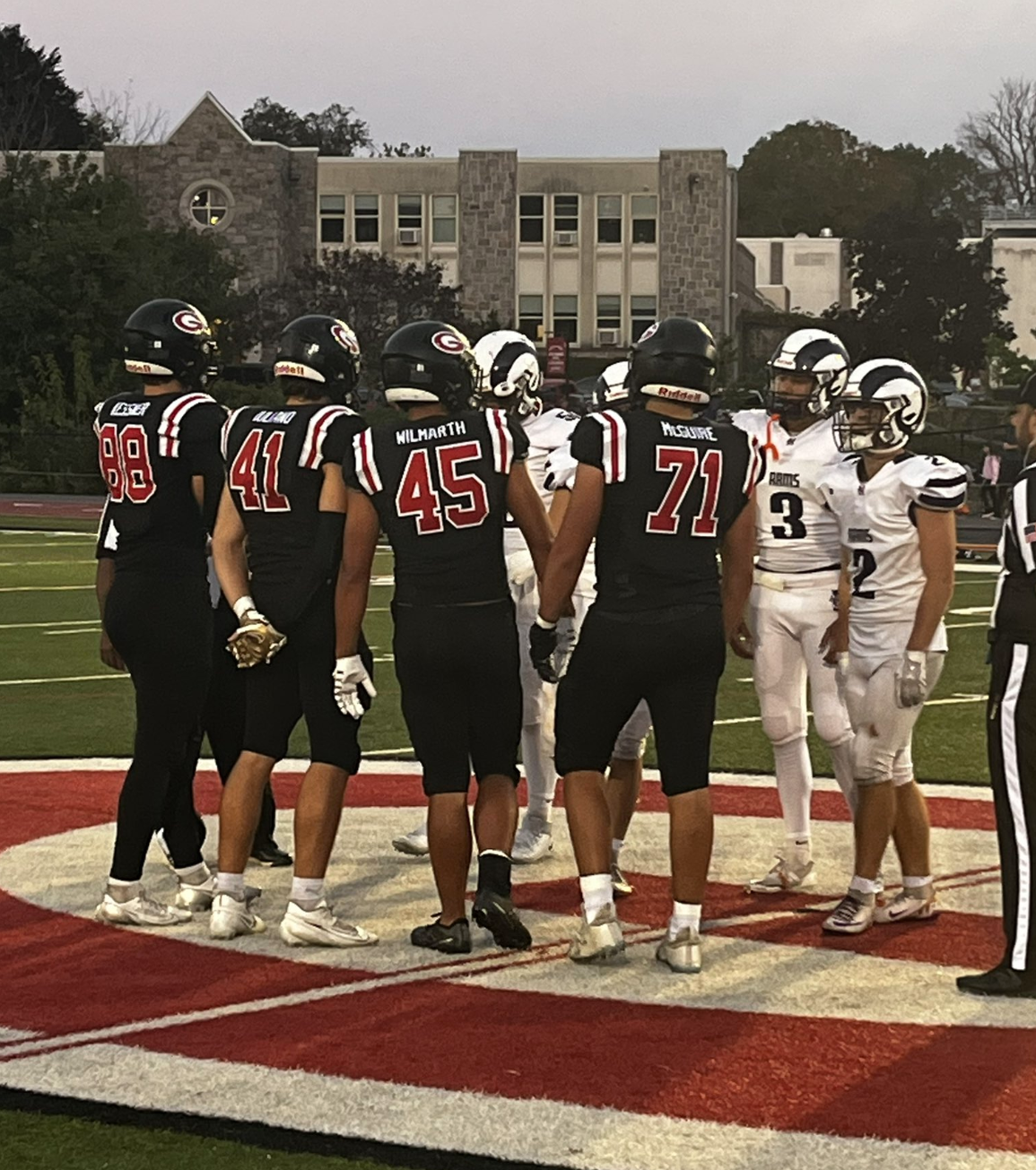 (PHOTO: Rye Football Captains Jake Kessner, Chris Iuliano, Andrew Wilmarth, and Patrick McGuire line up for the coin toss against Clarkstown North on Friday night.)